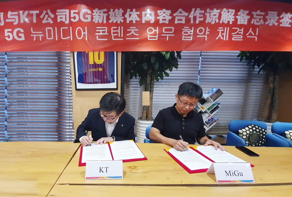 KT 뉴미디어사업단 김훈배 단장(왼쪽)과 차이나모바일 미구 류신(Liu Xin)’ 대표(오른쪽)가 협약서에 서명하고 있다. (사진=KT)